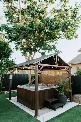 a wooden gazebo in a yard with a tree at Private Pool Chefs Kitchen BBQ 4min to SDSU in La Mesa