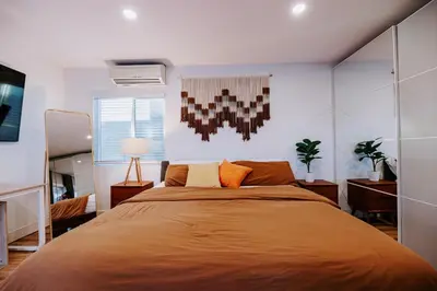 a bedroom with a large bed with orange sheets at Private Pool Chefs Kitchen BBQ 4min to SDSU in La Mesa