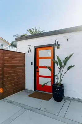 a garage with a red door and a potted plant at Private Pool Chefs Kitchen BBQ 4min to SDSU in La Mesa