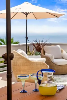 a table with two wine glasses and an umbrella at La Jolla Hilltop Haven with Ocean Views and Spa in San Diego