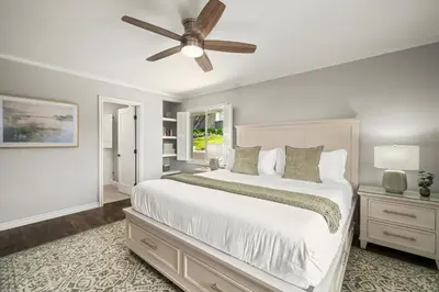 a bedroom with a white bed and a ceiling fan at La Jolla Hilltop Haven with Ocean Views and Spa in San Diego