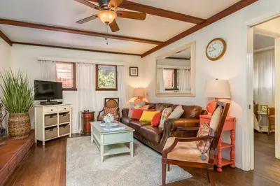 a living room with a couch and a tv at Redwood Hollow Cottages in San Diego