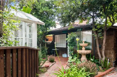 a house with a garden with a fountain in the yard at Redwood Hollow Cottages in San Diego
