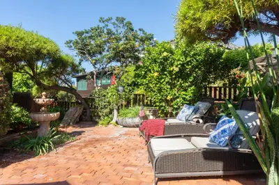 a patio with couches and a fountain in a yard at Redwood Hollow Cottages in San Diego