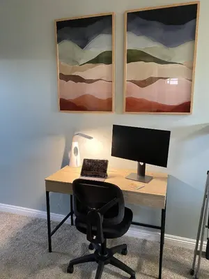a desk with a computer on it with two paintings at Beach Oasis in Carlsbad Village in Carlsbad