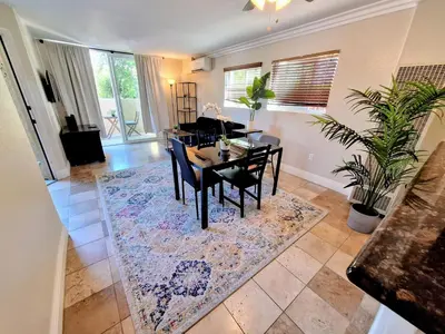 a dining room with a table and chairs on a rug at --Vacation First floor luxury condo La Jolla, Spa, Pool, Gym in San Diego