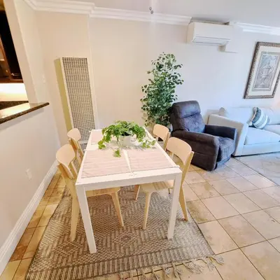 a dining room with a white table and chairs at --Vacation First floor luxury condo La Jolla, Spa, Pool, Gym in San Diego
