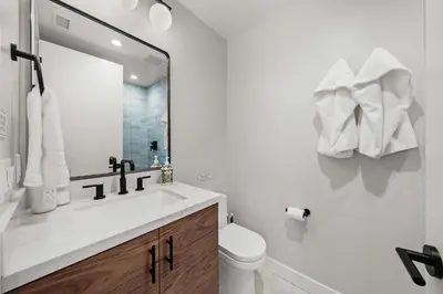 a bathroom with a sink and a toilet and a mirror at Del Mar Retreat - Laundry BBQ Firepit AC Patio in San Diego
