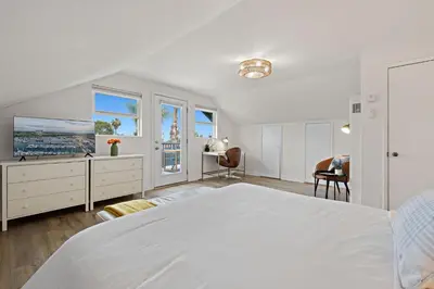 a white bedroom with a large bed and windows at Ocean-View, Deck, Steps to Beach Dining and More in Solana Beach