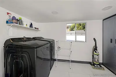 a kitchen with a black refrigerator and a window at Ocean-View, Deck, Steps to Beach Dining and More in Solana Beach