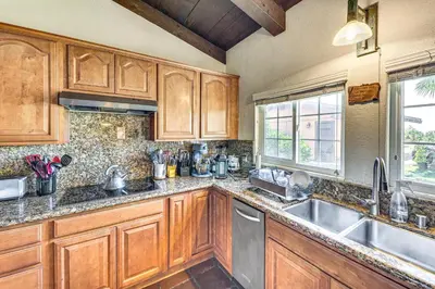 a kitchen with wooden cabinets and a sink at Stunning Valley and Mtn Views Elegant Temecula Home in Temecula