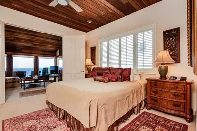 a bedroom with a bed and a table with a lamp at Luxury Oceanfront Home- Upper in Oceanside