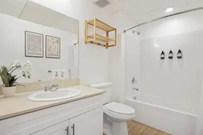 a white bathroom with a toilet and a sink at North Park Modern 2BR King Beds, Workspaces, Parking in San Diego