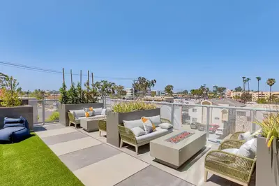 a patio with couches and chairs on a roof at North Park Modern 2BR King Beds, Workspaces, Parking in San Diego