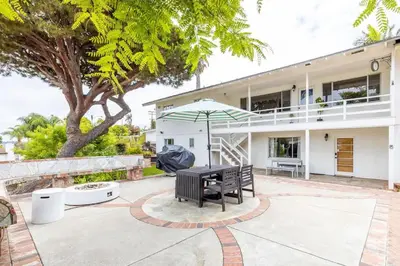 a bench and an umbrella in front of a house at Spacious 2 Bed in Carlsbad in Carlsbad