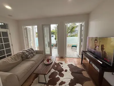 a living room with a couch and a flat screen tv at Private Encinitas Casita & Patio in Encinitas