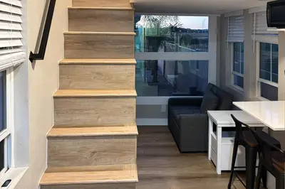 a set of stairs in a house with a couch at Pool and Hot Tub Access Cozy Perris Tiny Home in Perris