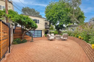 a patio with chairs and a table and a house at Seabreeze 1BR, Walk to Sand, Pet Friendly, Parking, Fire Pit Access in Carlsbad