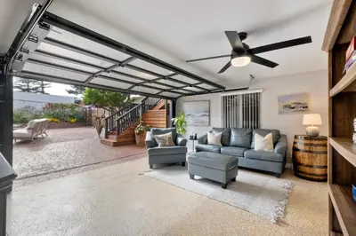 a living room with a ceiling fan and couches at Steps to Beach, 2BR Dog Friendly Home with Fire Pit in Carlsbad