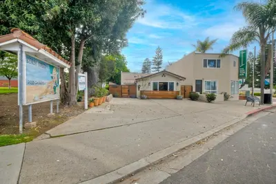a house with a sign in front of a driveway at Steps to Beach, 2BR Dog Friendly Home with Fire Pit in Carlsbad