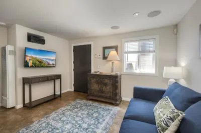 a living room with a blue couch and a table at Oceanside Bungalow, Walk to Beach & Pier, Private Hot Tub, Beach Gear in Oceanside
