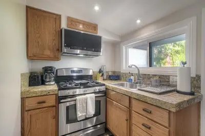 a kitchen with a stove and a sink at Oceanside Bungalow, Walk to Beach & Pier, Private Hot Tub, Beach Gear in Oceanside