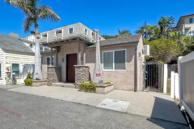 a house with a balcony on top of it at Oceanside Bungalow, Walk to Beach & Pier, Private Hot Tub, Beach Gear in Oceanside