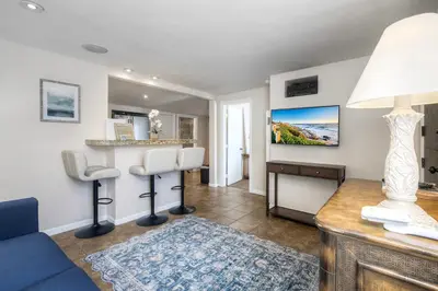 a living room with a couch and a table at Oceanside Bungalow, Walk to Beach & Pier, Private Hot Tub, Beach Gear in Oceanside