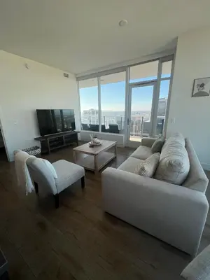 a living room with a white couch and a tv at The Daisy Bright 2BR Stay in Downtown San Diego in San Diego
