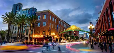 a busy city street at night with people crossing the street at The Daisy Bright 2BR Stay in Downtown San Diego in San Diego