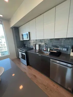 a kitchen with white cabinets and a stainless steel appliance at The Daisy Bright 2BR Stay in Downtown San Diego in San Diego