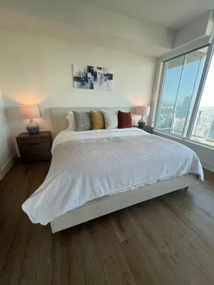 a white bedroom with a large bed with windows at The Daisy Bright 2BR Stay in Downtown San Diego in San Diego
