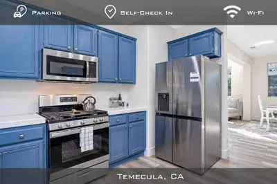 a kitchen with blue cabinets and a stainless steel refrigerator at Spacious Extended Stay Temecula in Temecula