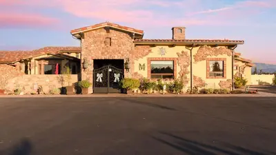 a large stone building with a large doorway at Soaking Tub Vineyard Views Wine Trail Access The Casita at Vines Estate by AvantStay in Temecula