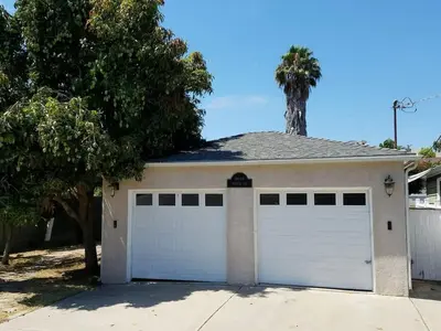 a white garage with a palm tree on top of it at The Hideaway in San Diego