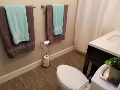 a bathroom with a toilet and towels on the wall at The Hideaway in San Diego