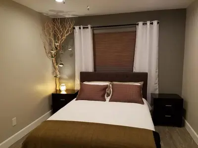 a bedroom with a bed with two night stands and a window at The Hideaway in San Diego