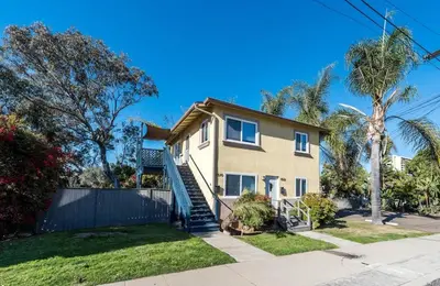 a house with palm trees and a fence at Canyon View in San Diego