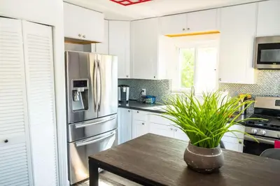 a kitchen with a table and a stainless steel refrigerator at Serenity in San Diego