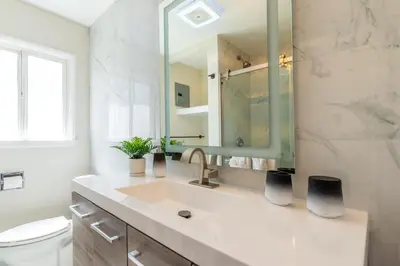 a bathroom with a sink and a mirror and a toilet at Allure Retreat in San Diego
