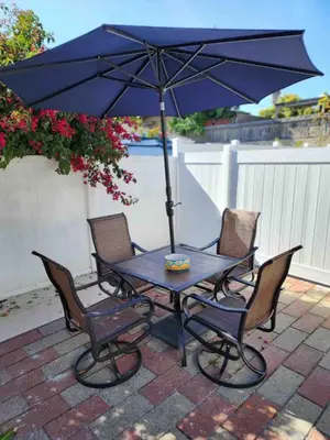 a table with chairs and an umbrella on a patio at Allure Retreat in San Diego
