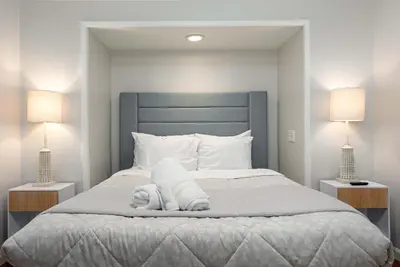 a bed with a stuffed animal on it with two lamps at Central Backyard Oasis Villa in San Diego