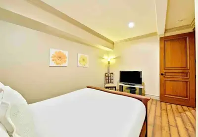 a bedroom with a white bed and a television at Stunning Views, Rooftop Vista, Pool & Spa in San Diego