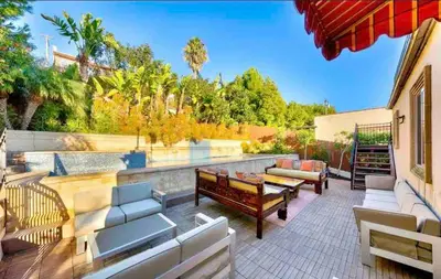 a patio with couches and tables and a wall at Stunning Views, Rooftop Vista, Pool & Spa in San Diego