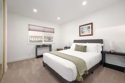 a bedroom with a large white bed and a window at Luxury Home OceanView in San Diego