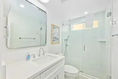 a white bathroom with a sink and a shower at Sail & Sea in Newport Beach