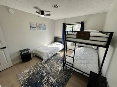 a bedroom with two bunk beds and a rug at Family Fun Getaway - 3BR - Games - BBQ Patio in Santee