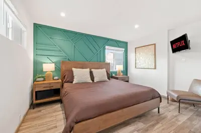 a bedroom with a large bed with a green wall at Ocean Views Steps to Beach Rooftop Firepit in San Diego