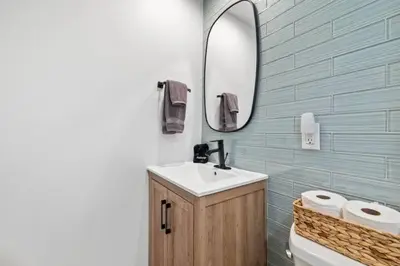 a bathroom with a sink and a mirror and a toilet at Ocean Views Steps to Beach Rooftop Firepit in San Diego