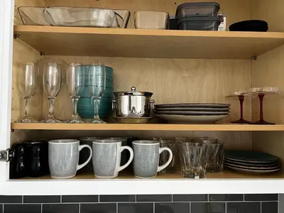 a shelf filled with cups and plates and glasses at Cozy Luxurious Spacious Apt with Valley View, Attached Garage,Pool,24-Hour Gym, 3 TV in Mission Viejo